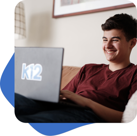 Старшеклассник в красной рубашке работает на ноутбуке K12